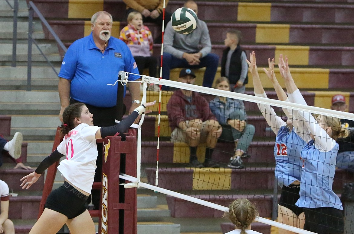 Moses Lake senior Makenna Stuart, in white, tips the ball over the net during the first set against West Valley (Yakima). Stuart led the Mavs with 10 kills.