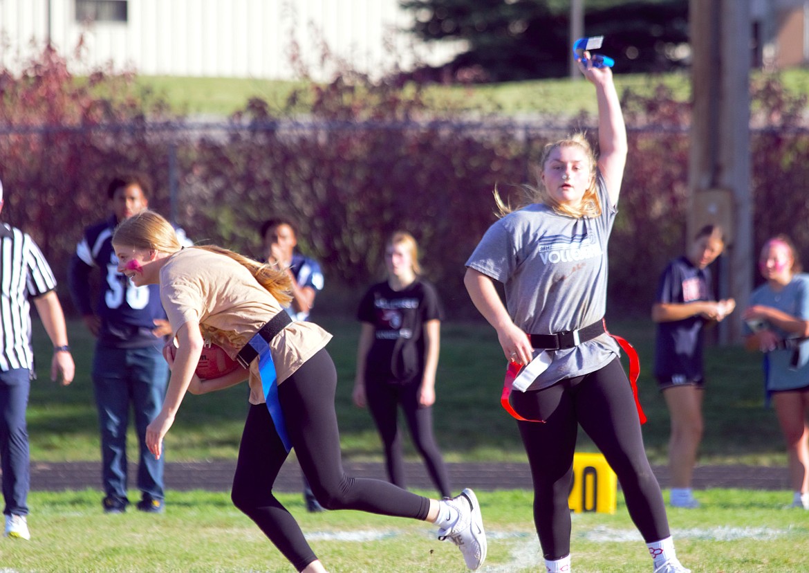 (right) Senior Savannah pulls a sophomore's flag during Powderpuff flag football in the Championship game.