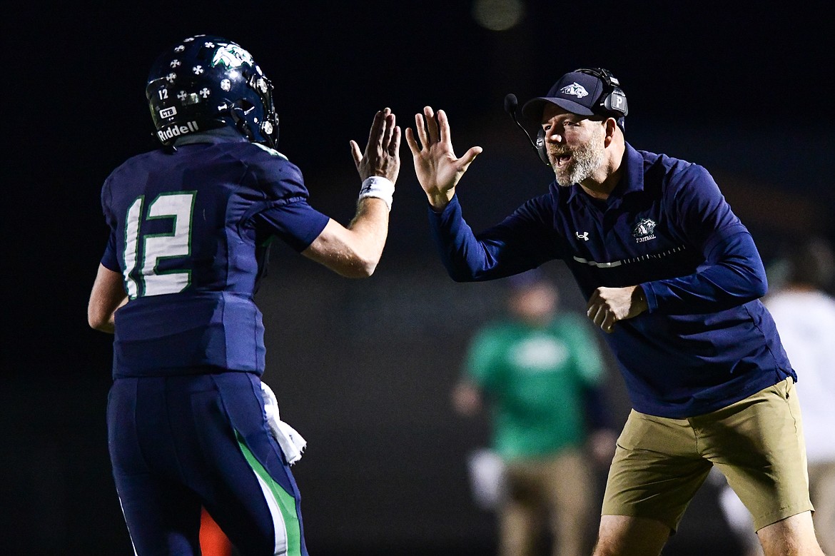 Glacier head coach Grady Bennett congratulates quarterback Jackson Presley (12) after Presley's touchdown run in the first quarter against Missoula Sentinel at Legends Stadium on Thursday, Oct. 19. (Casey Kreider/Daily Inter Lake)