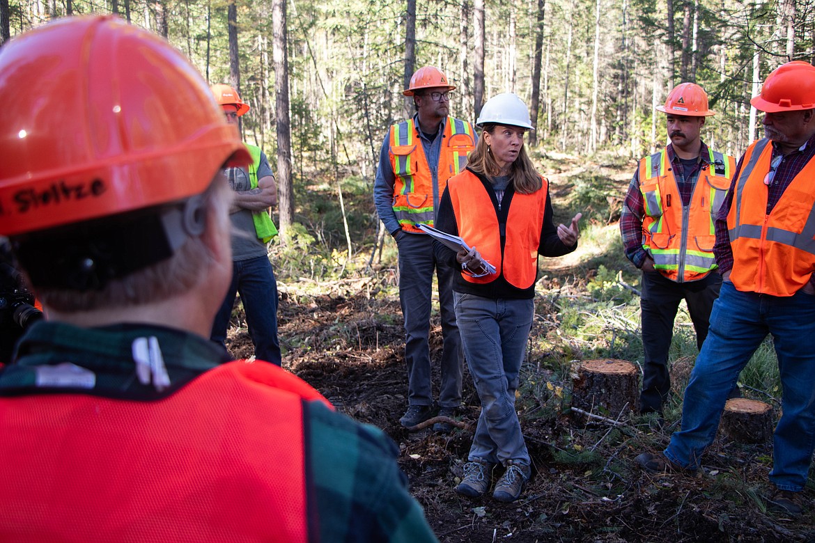 Ali Ulwelling, a Montana Forest Plan implementation coordinator at the state Department of Natural Resources and Conservation, speaks to a group touring a lumber landing on Oct. 18, 2023. (Kate Heston/Daily Inter Lake)