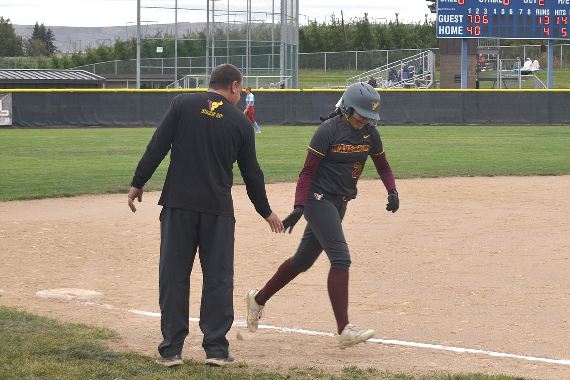 Moses Lake sophomore Alina Lopez, right, high-fives Moses Lake coach Mike Hofheins after rounding third base against West Valley (Yakima) on Tuesday.