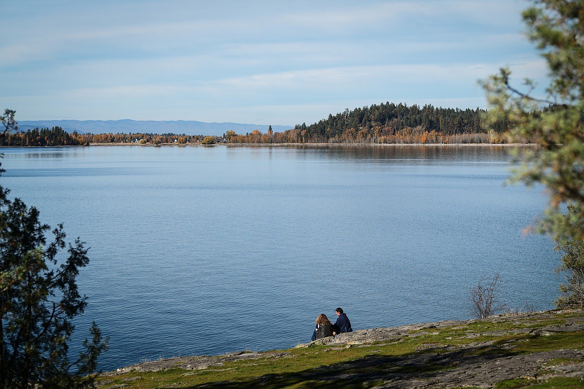 A man and woman sit and talk along the cliffs over Flathead Lake at the Wayfarers unit of Flathead Lake State Park on Friday, Oct. 20. (Casey Kreider/Daily Inter Lake)