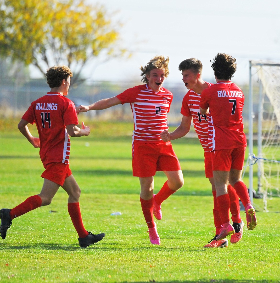 Sandpoint's Connor McClure (14), Noah Wagner (2), Caiden Gion (19), and Henry Barnes (7) celebrate after a goal scored by Gion during the 52nd minute in the Bulldogs' 3-2 win on Friday.