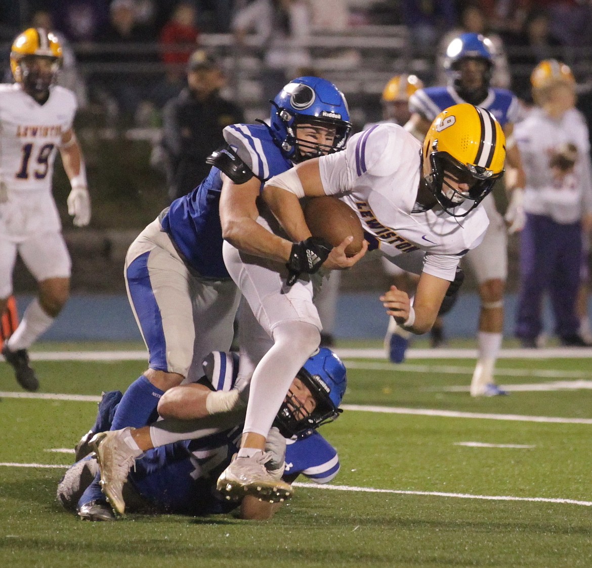 MARK NELKE/Press
Coeur d'Alene senior Tanner Ackley and a Viking teammate tackle Lewiston quarterback Drew Hottinger on Friday night at Coeur d'Alene High.