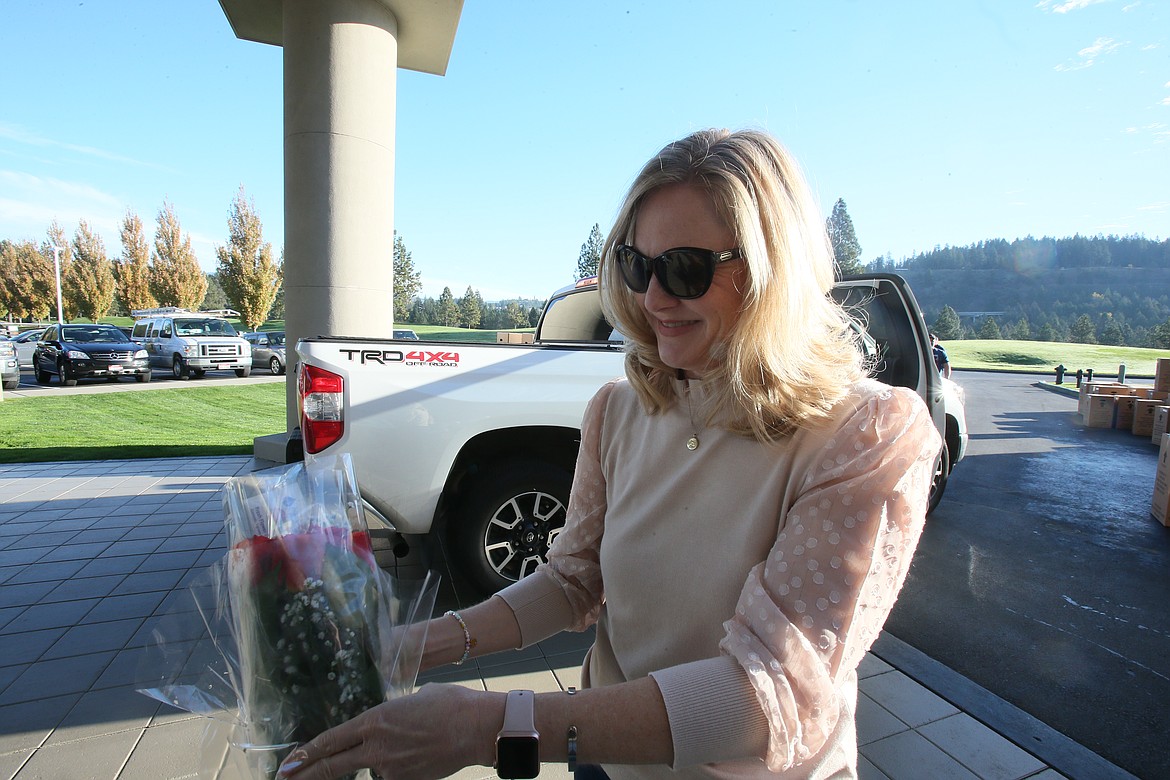 Britt Towery bags a dozen red roses Friday morning at the Hagadone Event Center during the Coeur d'Alene Rotary Club's Rose Sale distribution event.