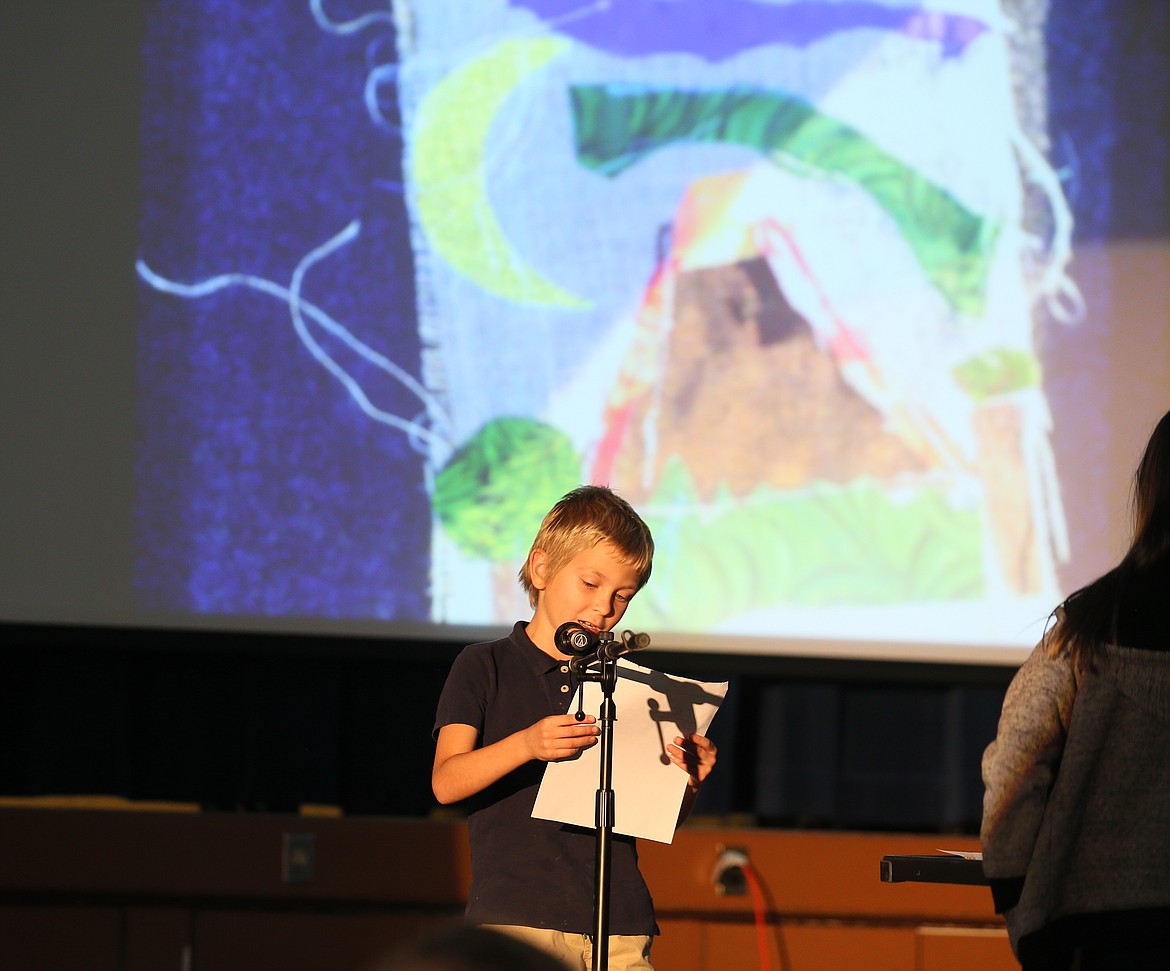 Third grader Henry Hermance reads his artist's statement to his peers and visiting family members during Sorensen Magnet School's Friday gathering in the gym.