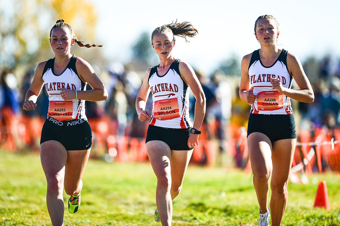 Flathead's Lilli Rumsey Eash, Josie Wilson and Mikenna Conan run the course in the Class AA girls race at the state cross country meet at Rebecca Farm on Saturday, Oct. 21. (Casey Kreider/Daily Inter Lake)