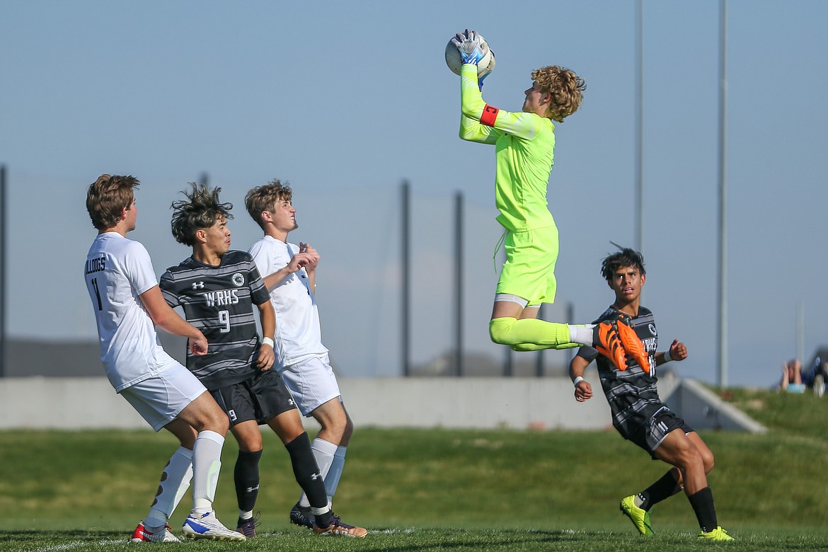 Sandpoint's goalkeeper Kai Longanecker jumps high in the air near the edge of the box in order to prevent a try from Wood River during Saturday's state title match.