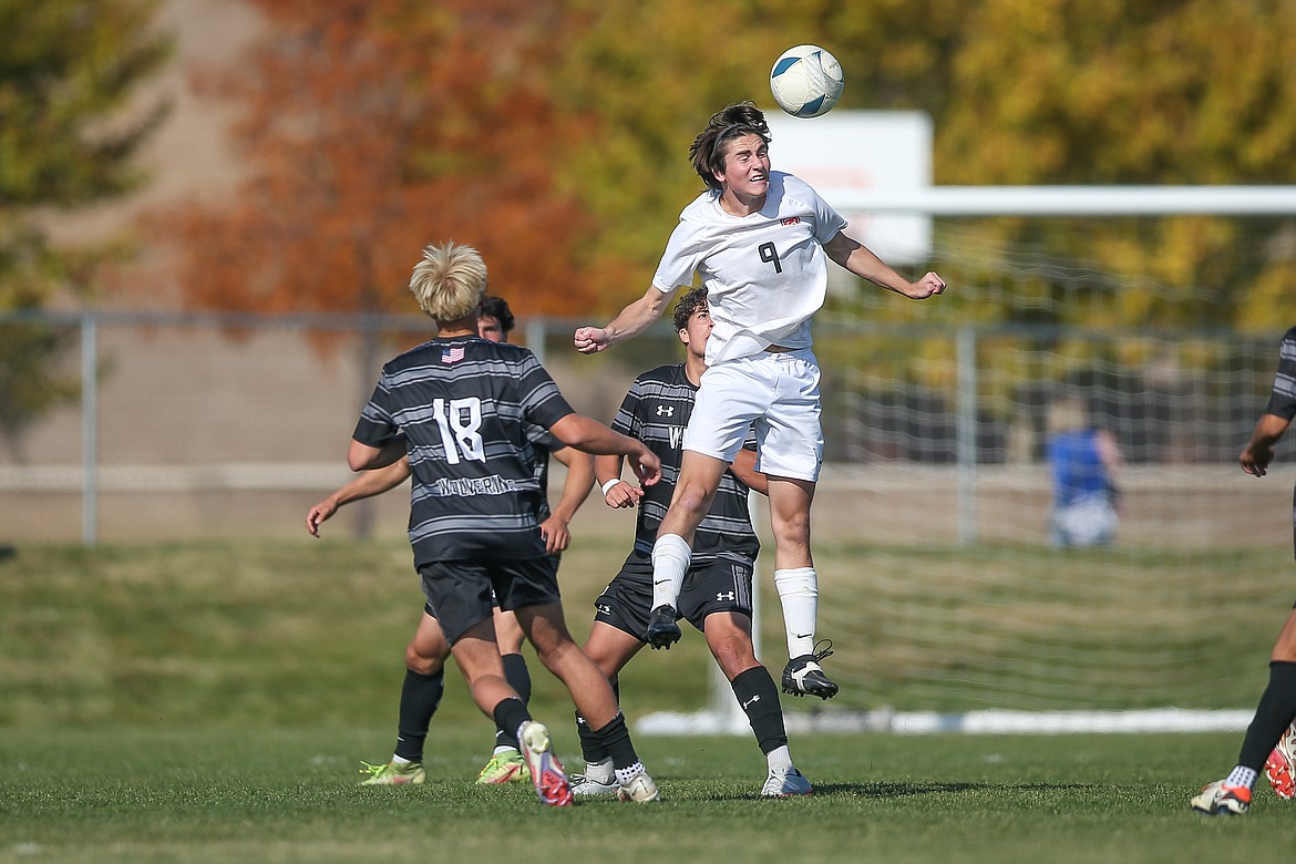 Sandpoint senior Eoin Eddy heads the ball while surrounded by three Wood River defenders during Saturday's state title match.