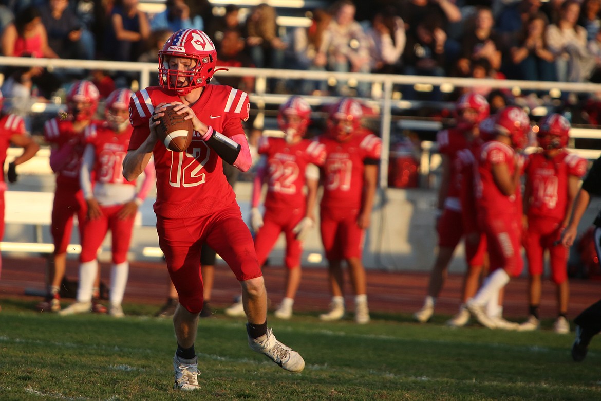 Othello senior Spencer Lawson rolls out of the pocket in the first half.