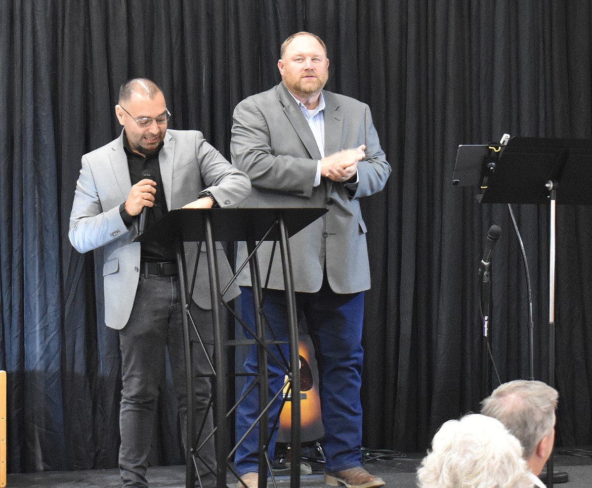 Pastor Joey Uresti of Malone Assembly Outpost Church, Moses Lake, left, flanked by emcee Chuck Yarbro Jr., prepares  to offer the opening prayer at the Crossroads Resource Center banquet Saturday.