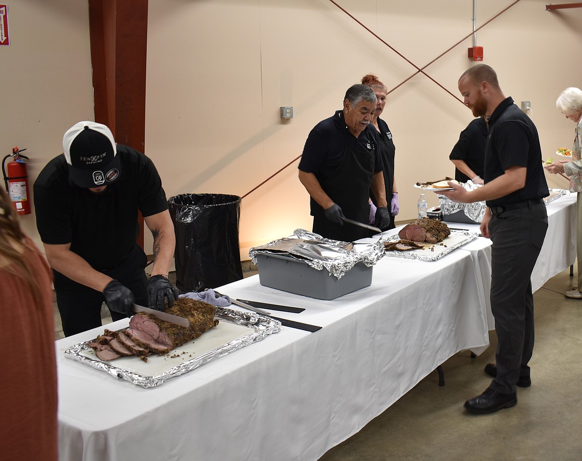 Staff from Top Gun Concessions & Catering carve prime rib at the Crossroads Resource Center banquet Saturday.