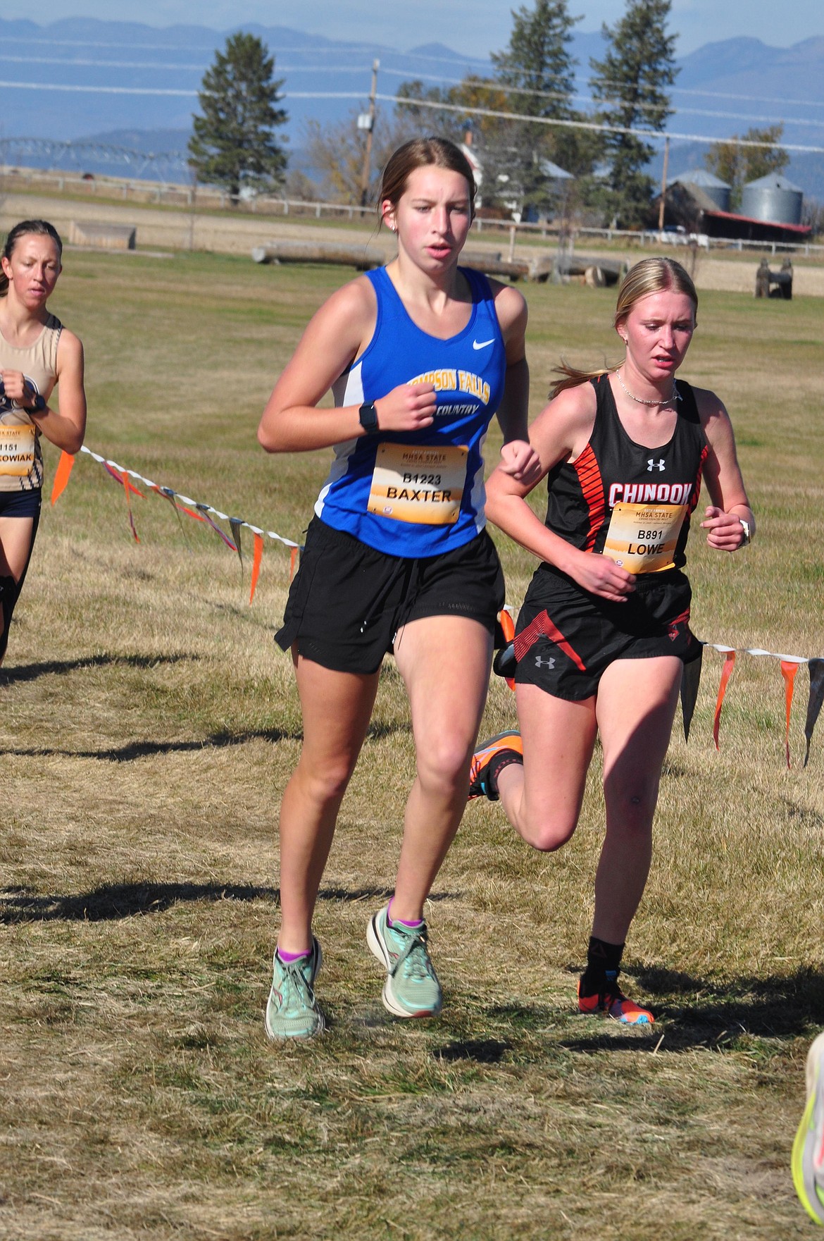 Thompson Falls freshman Aubrey Baxter passes a runner from Chinook High during Saturday's Montana State Cross Country championships in Kalispell.  Baxter placed 26th out of 172 Class B women runners.  (Photo by Sarah Naegeli)