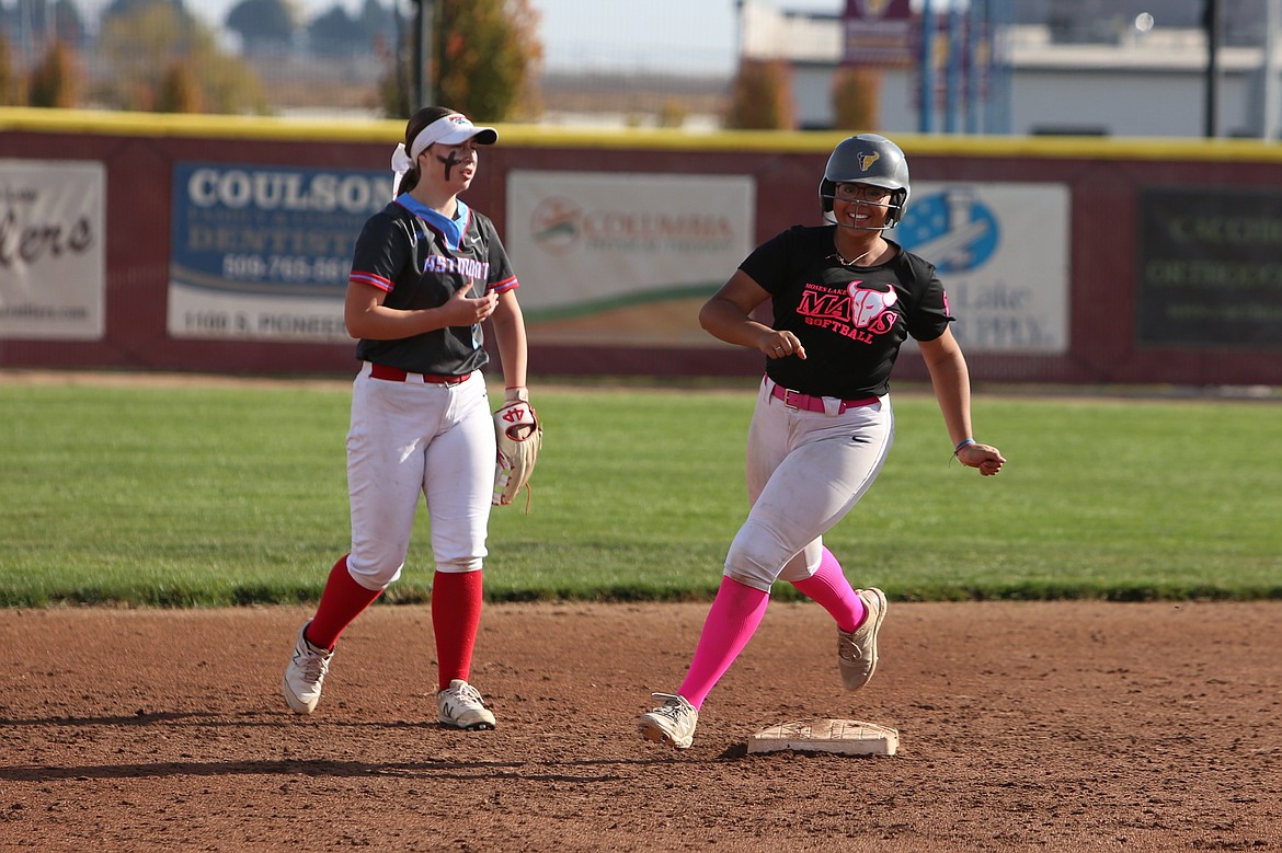 Moses Lake freshman Amelia Avalos, right, smiles while rounding second base after hitting a home run against Eastmont.