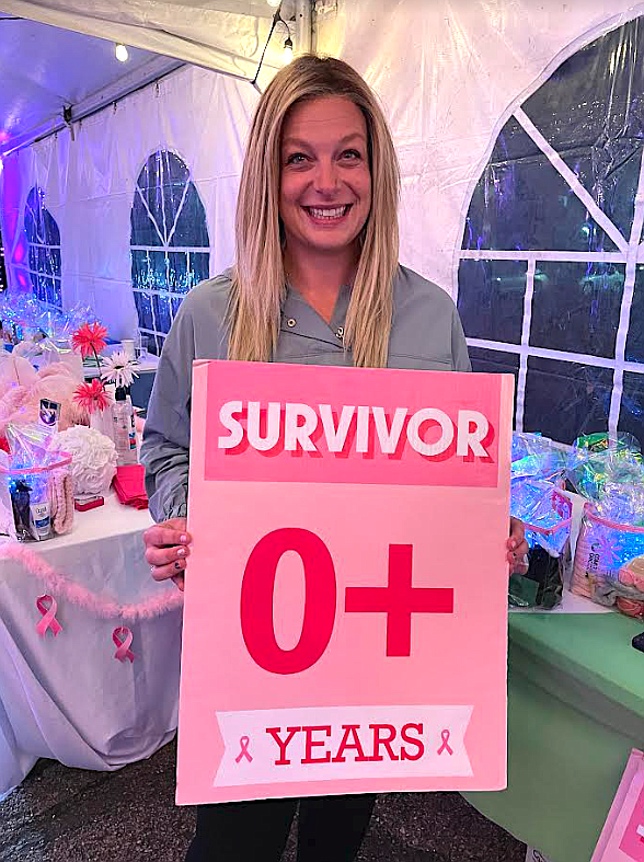 Kate Stevens, 34, of Coeur d'Alene, holds a breast cancer survivor sign at Kootenai Health's breast cancer awareness Pamper Me Pink event Oct. 19. She was diagnosed with an aggressive breast cancer about a year ago after she found a lump. She was convinced to get checked following the event. "Don’t let fear win,” Stevens said. "If you find something, get it checked and if they don't take it seriously, find someone else to check it.”