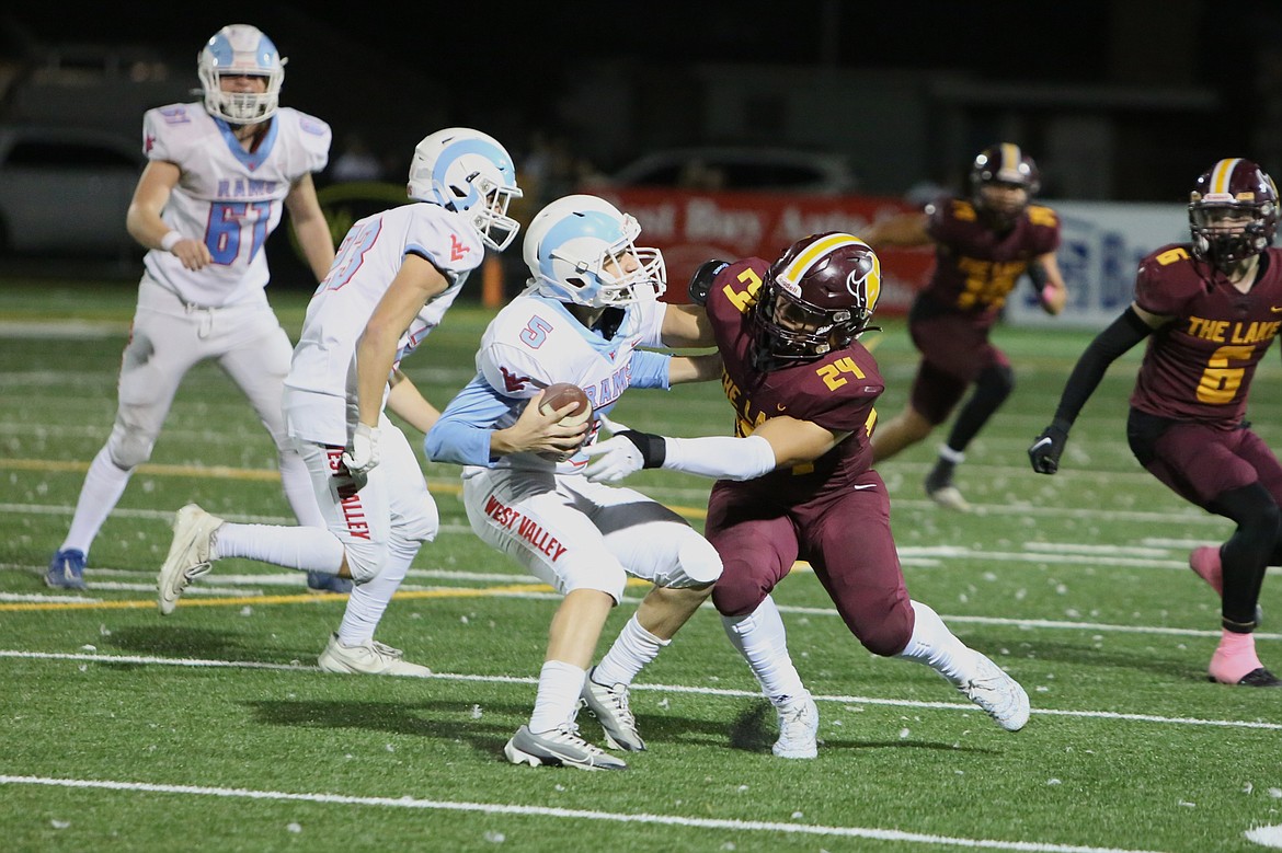 Moses Lake freshman Petrah Mackenzie (24) tackles West Valley’s quarterback in the second half of Friday’s win.