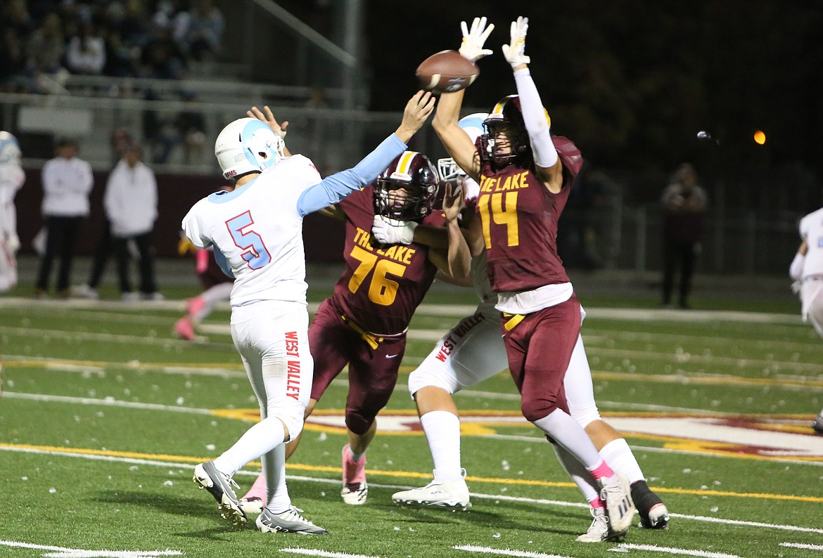 Moses Lake senior Wyatt Keller (14) raises his arms in an attempt to break up a West Valley pass in the second half.