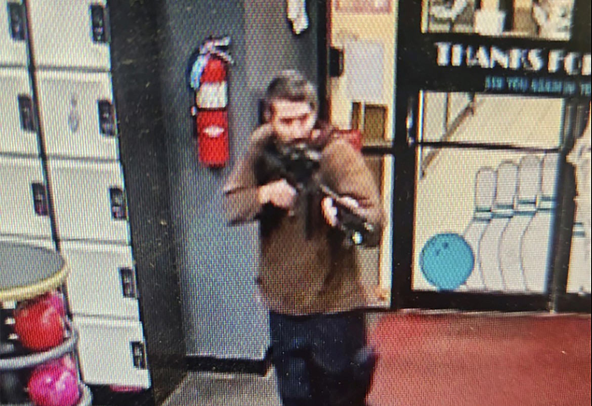 In this image taken from video released by the Androscoggin County Sheriff's Office, an unidentified gunman points a gun while entering Sparetime Recreation in Lewiston, Maine, on Wednesday, Oct. 25, 2023. Maine State Police ordered residents in the state's second-largest city to shelter in place Wednesday night as the suspect remains at large. (Androscoggin County Sheriff's Office via AP)