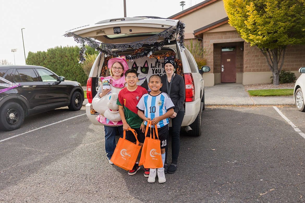 Adams County Pet Rescue Board Member Tammy Foley and Othello resident Kim Bailey stand with children at the Trunk or Treat event during the Greater Othello Chamber of Commerce’s Family Fall Festival Saturday.