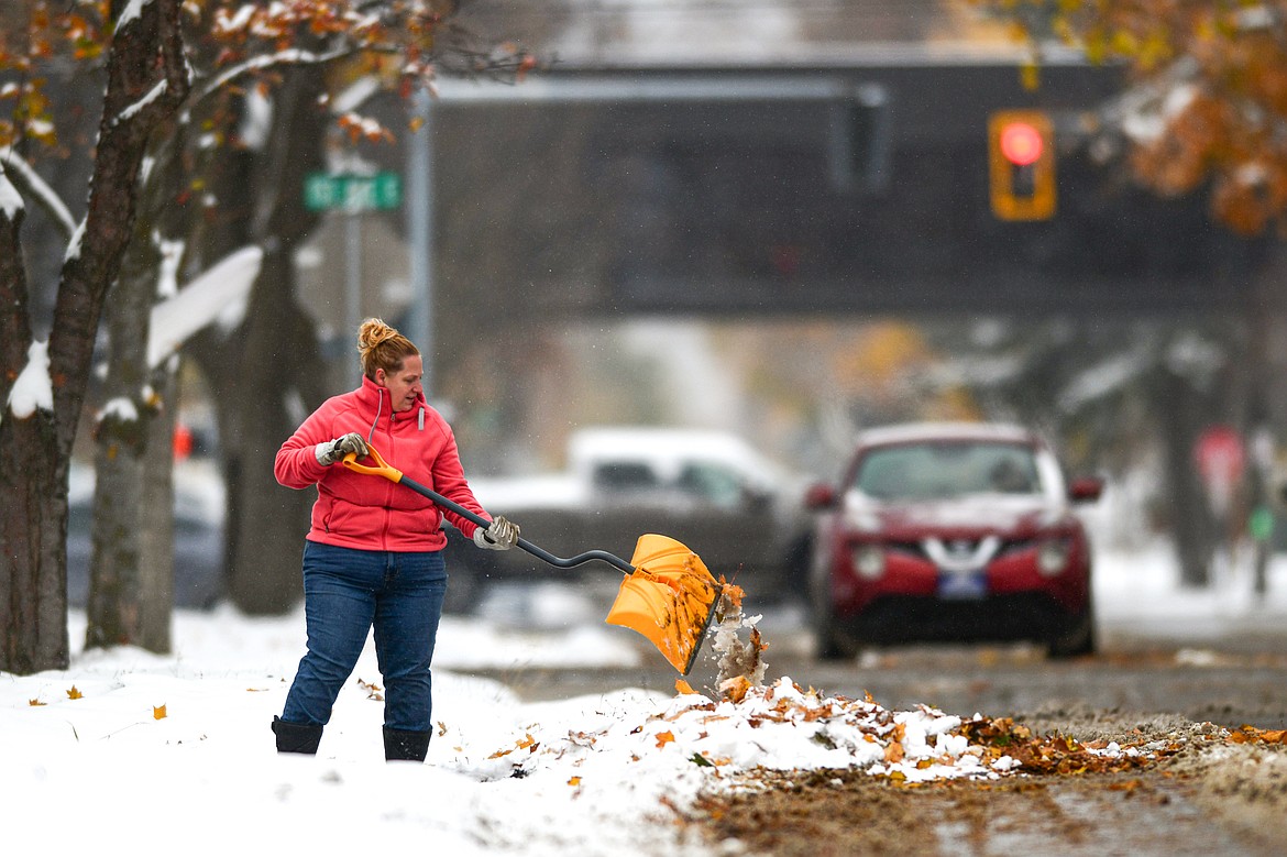 A resident of 11th Street East shovels a mix of snow and fallen leaves on Wednesday, Oct. 25. (Casey Kreider/Daily Inter Lake)