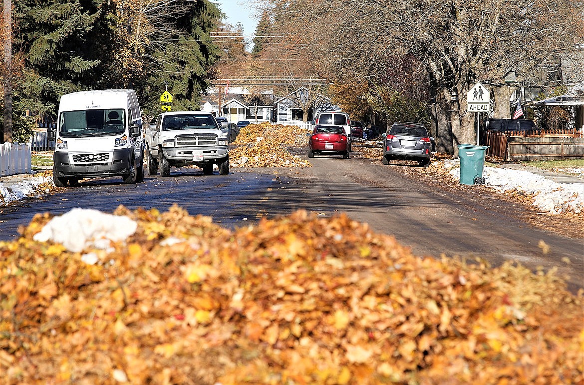 Drivers pass by piles of leaves on Seventh Street in November 2022. Residents are encouraged to start putting leaves/needles out after Nov. 1.