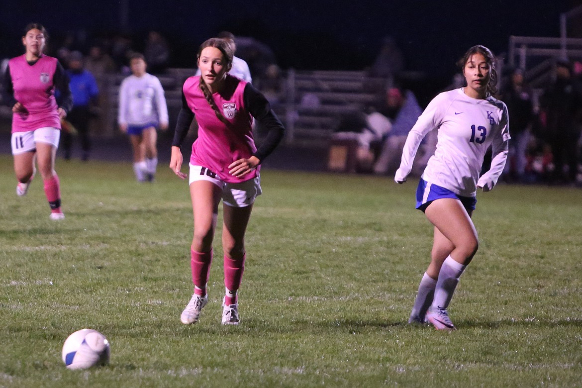 Wahluke freshman Morgan Harlow, left, moves upfield against the Kiona-Benton defense on Tuesday night.