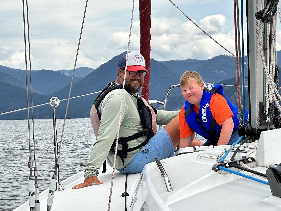 Dogsmile Adventures founder Capt. Jon Totten and young sailor Mark Poncato with Specialized Needs Recreation are pictured aboard the SV Dogsmile on Lake Pend Oreille. Dogsmile Adventures, a North Idaho therapeutic sailing nonprofit, will hold its annual celebration and Race to Alaska film premiere online Nov. 14 at 6:30 p.m.