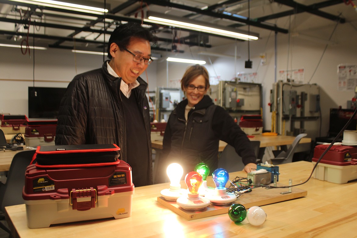 Gina Cutts, right, industrial systems technology instructor at Big Bend Community College, demonstrates a method for teaching three-phase electrical systems to Washington Department of Commerce Director Mike Fong, left.