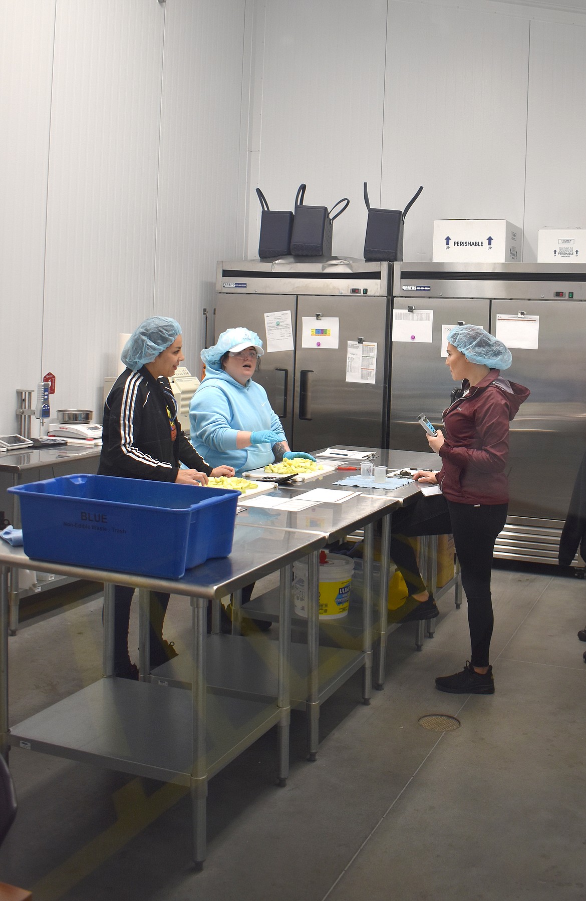 Okanagan Specialty Fruits employees perform quality control spot checks on sliced apples at the company’s new Moses Lake facility.