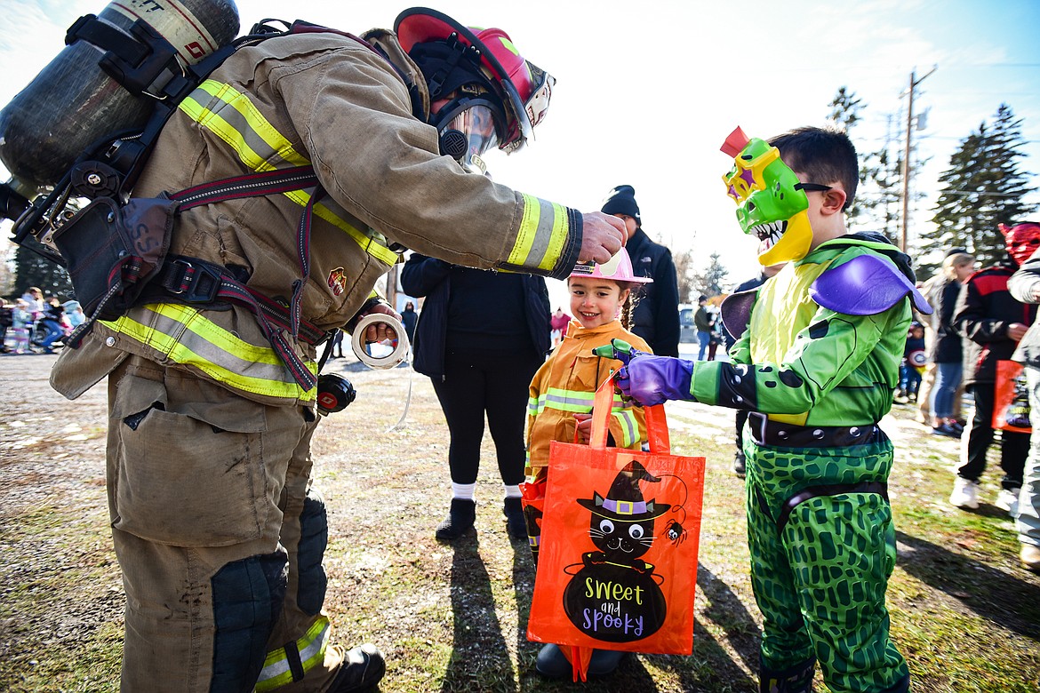 Evergreen Fire Captain James Boyce gives a child a piece of candy at the trunk or treat event at the Boys and Girls Club of Glacier Country headquarters in Evergreen on Saturday, Oct. 28. The event was sponsored by the Flathead County Sheriff's Posse, Evergreen Chamber of Commerce and local first responders. (Casey Kreider/Daily Inter Lake)