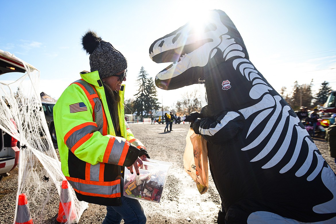 Dressed in a dinosaur skeleton suit, Jaxon Clarke receives a piece of candy at the trunk or treat event at the Boys and Girls Club of Glacier Country headquarters in Evergreen on Saturday, Oct. 28. The event was sponsored by the Flathead County Sheriff Posse, Evergreen Chamber of Commerce and local first responders. (Casey Kreider/Daily Inter Lake)