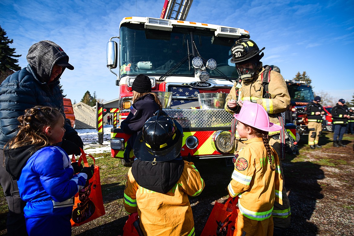 Firefighters with Evergreen Fire Rescue hand out candy at the trunk or treat event at the Boys and Girls Club of Glacier Country headquarters in Evergreen on Saturday, Oct. 28. The event was sponsored by the Flathead County Sheriff's Posse, Evergreen Chamber of Commerce and local first responders. (Casey Kreider/Daily Inter Lake)