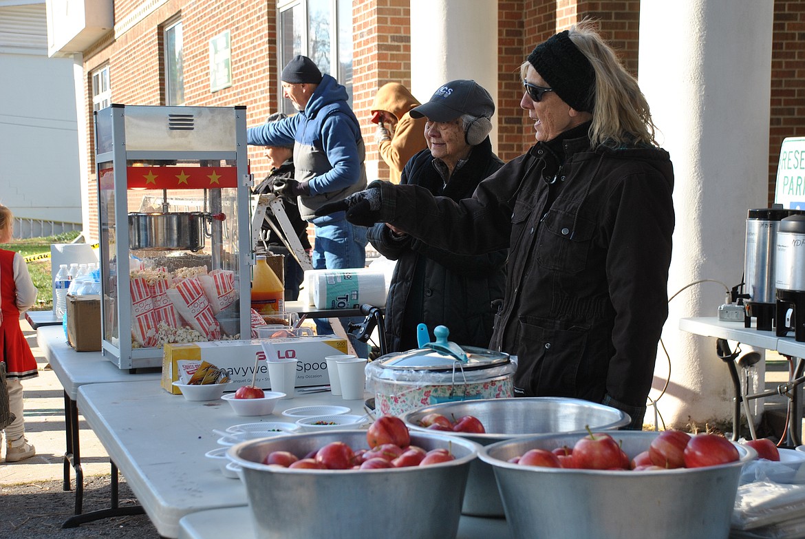 Church members from New Day Fellowship served caramel apples, popcorn, and hot cocoa in frigid temperatures Saturday afternoon during the 2nd annual St. Regis Fall Festival put on by NDF and the St. Regis Community Council. (Mineral Independent/Amy Quinlivan)