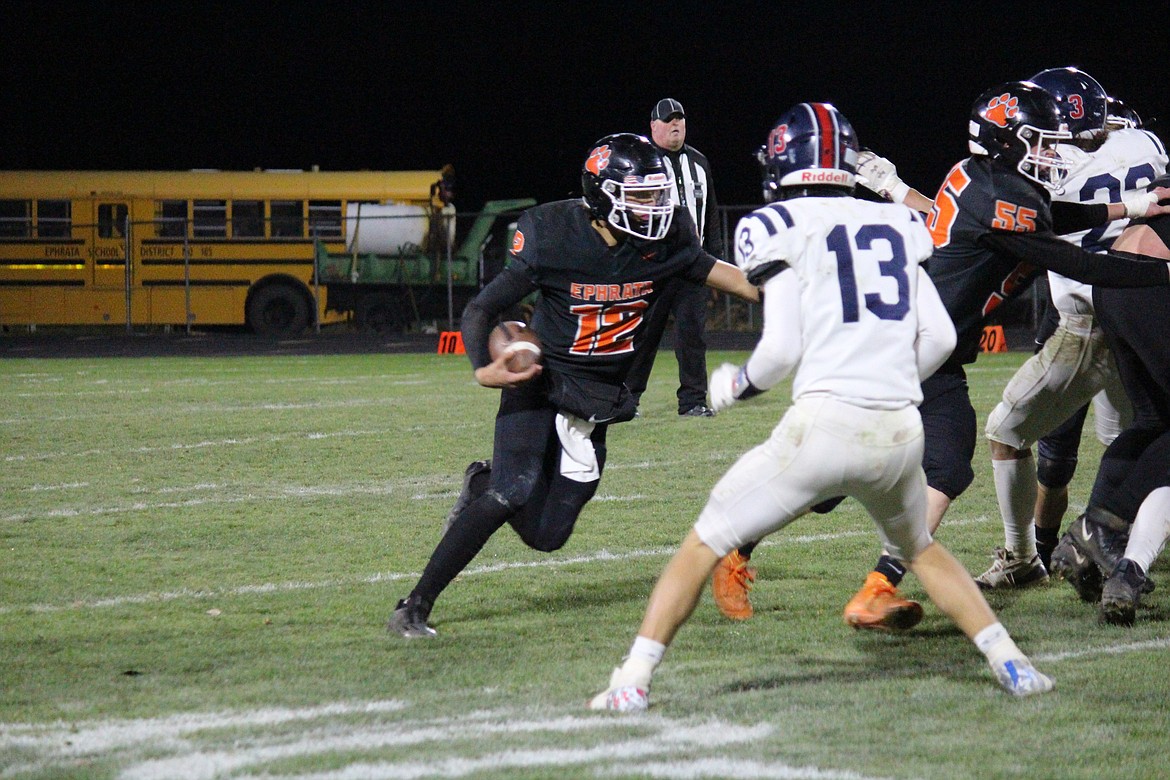 Ephrata quarterback Brady Hendrick (12) makes his way downfield in the Tigers’ 13-0 win over Ellensburg Friday.