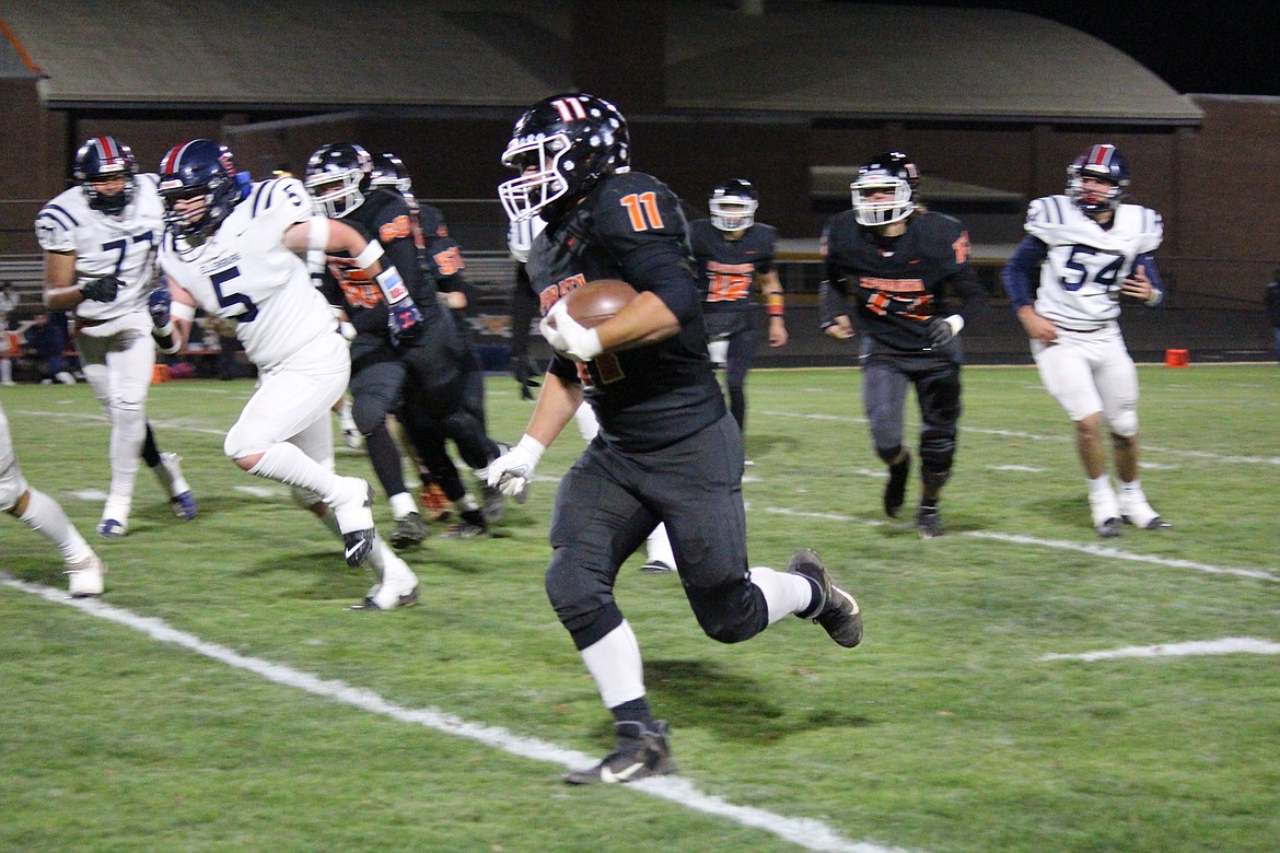 Ephrata running back Eric O’Neel (11) heads off-tackle against Ellensburg.