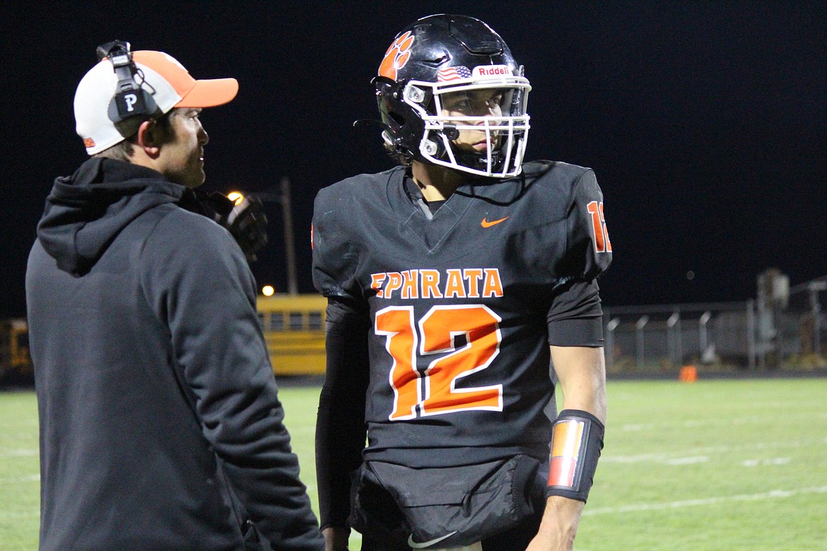 Ephrata coach Patrick Mitchell, left, gives a play to quarterback Brady Hendrick, right, during Ephrata’s Friday win over Ellensburg.