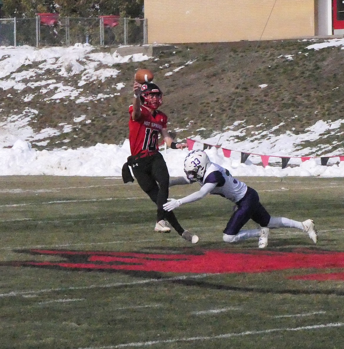 Hot Springs quarterback Nick McAllister is hit by Valier's Tristen Valdez (33)as he releases a pass during their first round playoff game Saturday afternoon in Hot Springs. (Chuck Bandel/VP-MI)