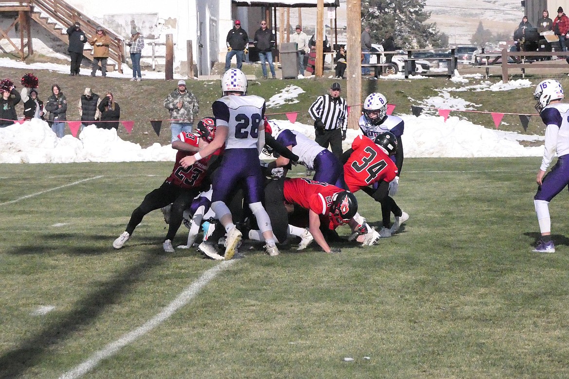 Junior running back David Chapman (red jersey, #334) crosses the pile of players at the goal line to score the Savage Heat's first touchdown against Valier in a first round playoff game Saturday in Hot Springs.  (Chuck Bandel/VP-MI)