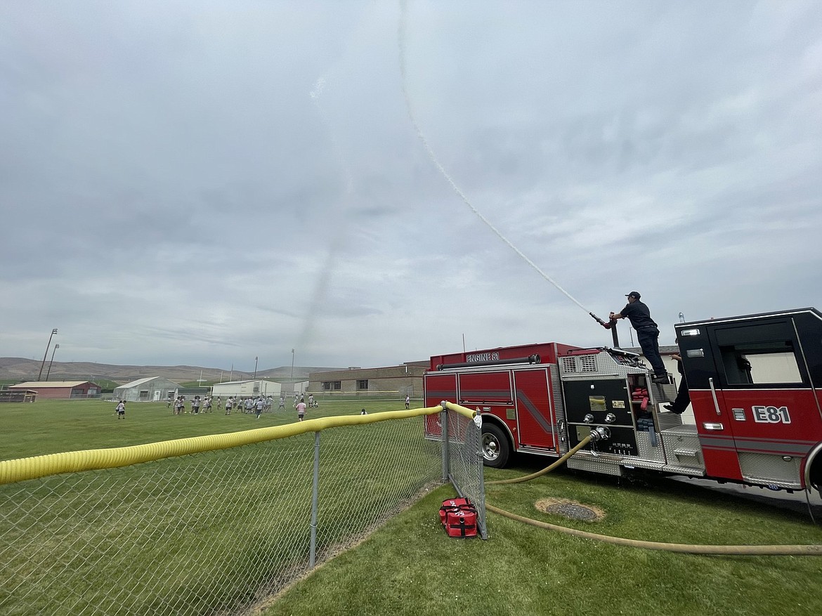 A Grant County Fire District 8 fire truck entertains kids on a sports field in Mattawa.