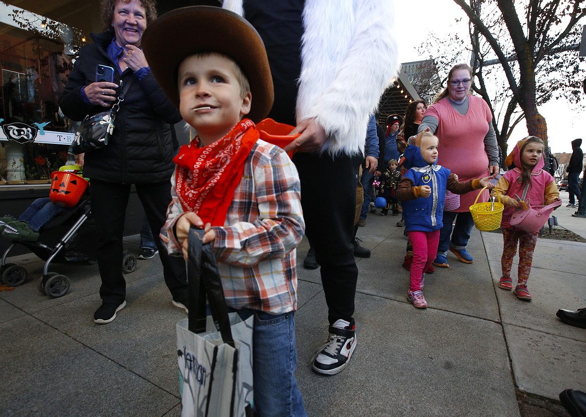 Carson Wuest, joined by his grandmother, Dena Wuest, left, smiles after receiving a treat in downtown Coeur d'Alene on Thursday.Hundreds of costumed kids and parents haunted stores and The Coeur d'Alene Resort in search of candy on Thursday.