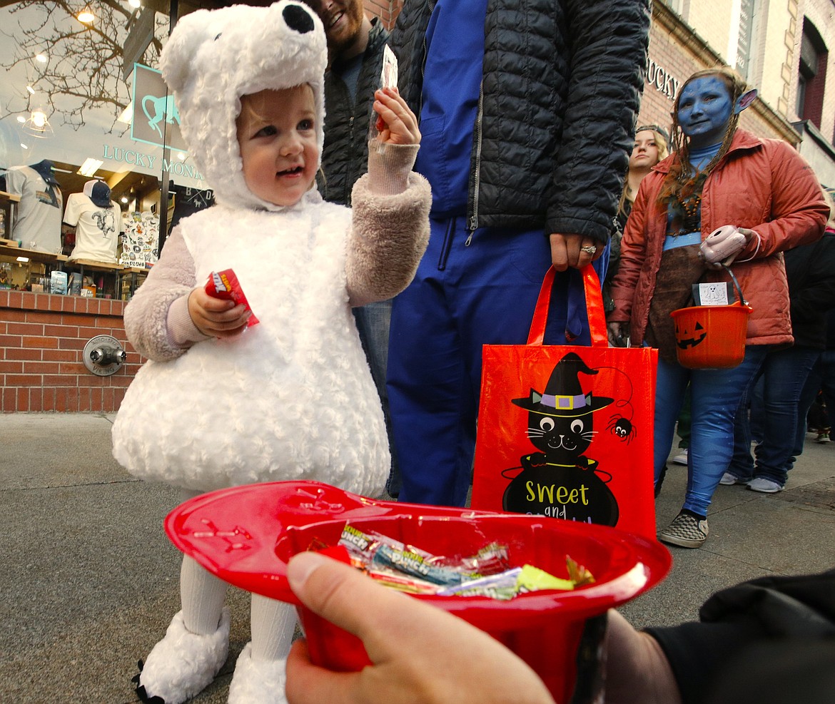 Grace Lehner checks out the candy she received in downtown Coeur d'Alene on Thursday. Hundreds of costumed kids and parents haunted stores and The Coeur d'Alene Resort in search of treats on Thursday.