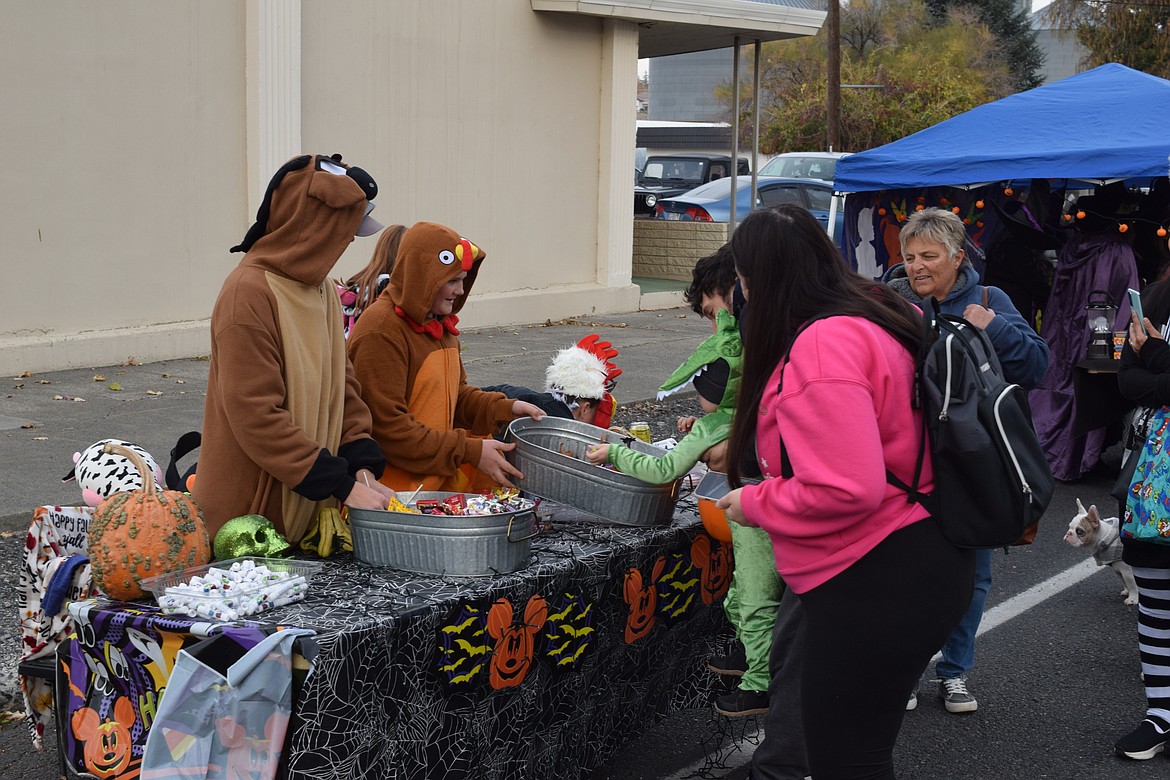 Balanced Body Massage handed out tubs of candy and smiles with the help of these two “therapy animals.” We’re sure the young alligator shown digging through the candy tubs appreciated their help.