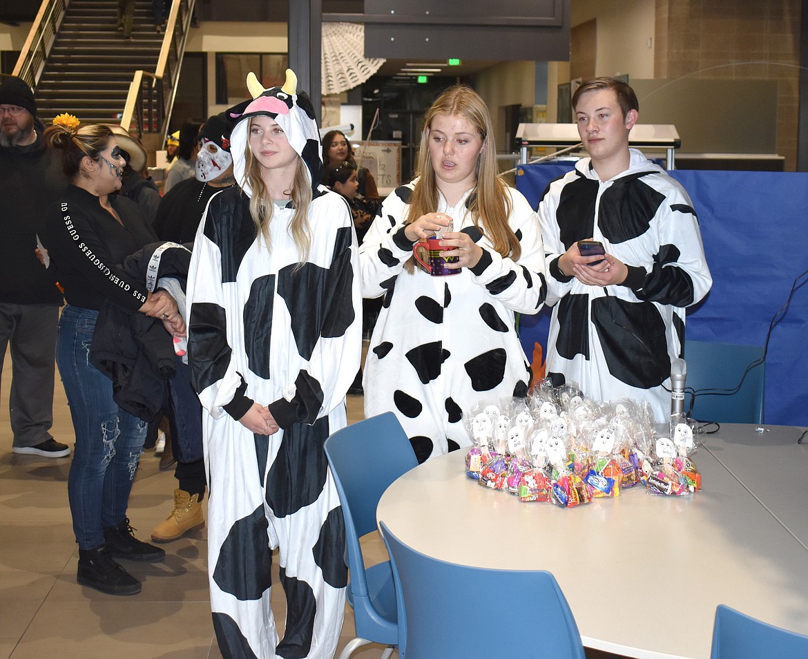 From left: Ashlynn Greene, Halle Hies and Devin Mackey start ad stop the music at the pumpkin walk at Vanguard’s Halloween event Tuesday evening.