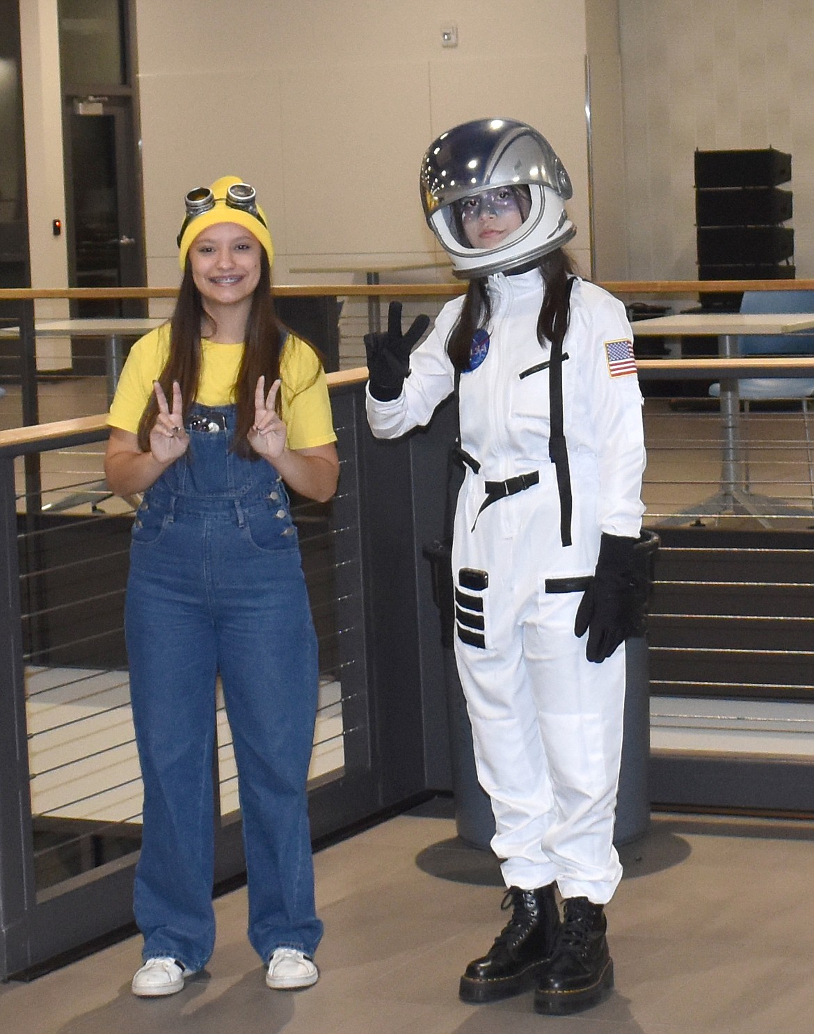 Alyssa Wassink, left, and Selena Ramirez greet trick-or-treaters at the beginning of the spider-strewn path to the haunted houses created by Houses Six and Four at Vanguard Academy’s Halloween event Tuesday.