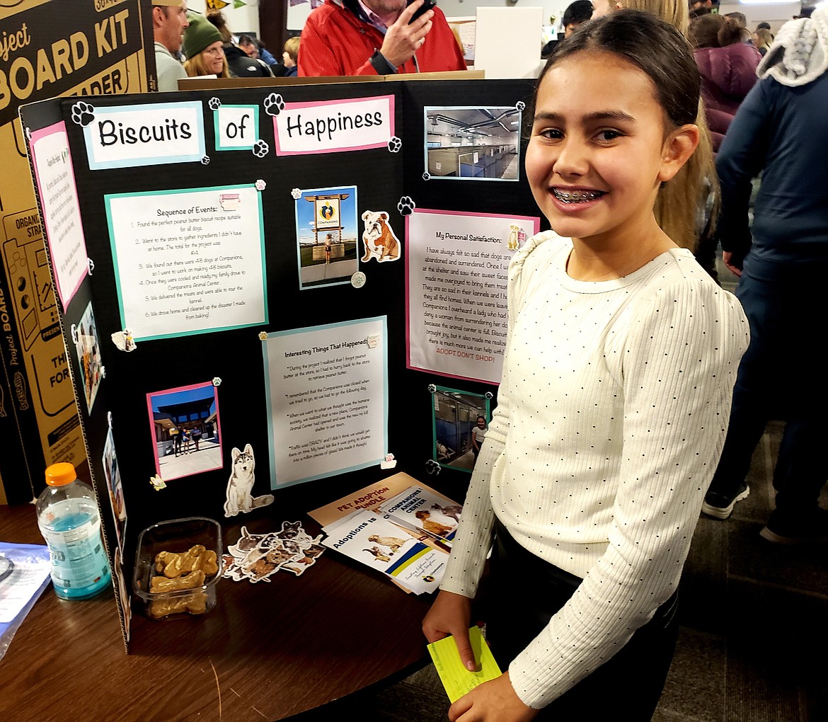 Coeur d'Alene Charter Academy sixth grader Arden Mickelson presents her good deed project Wednesday. She baked biscuits for 48 dogs at Companions Animal Shelter for her project.