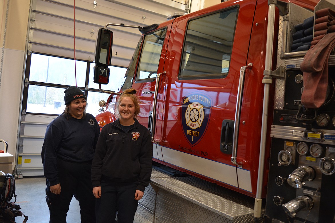 Averie Kinsey  and Paige Bischofberger stand by a Shoshone County District No. 1 firetruck in Osburn. Kinsey is a probationary firefighter at Shoshone County District No. 2 and Bischofberger is a firefighter and EMT for Shoshone County District No. 1.