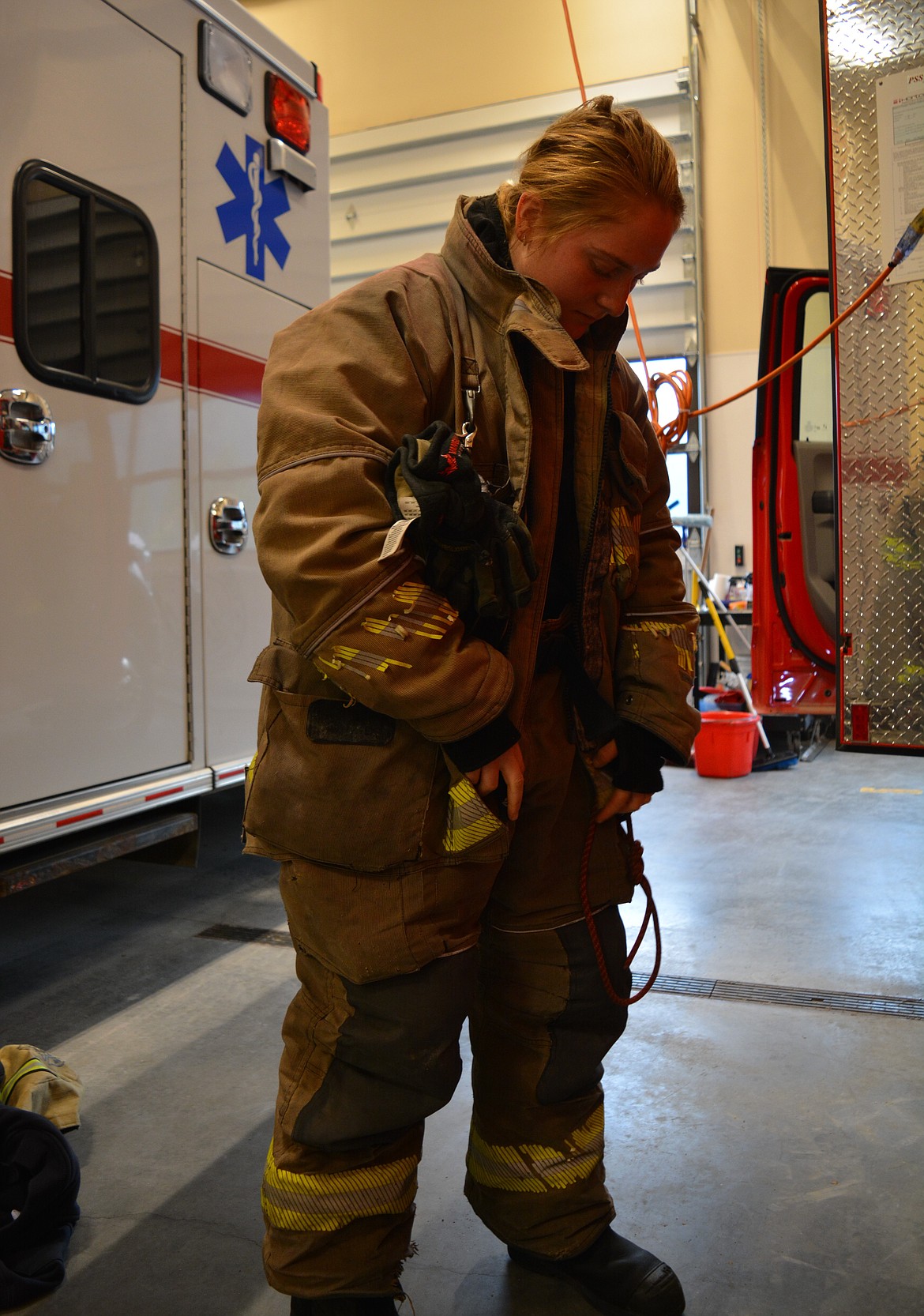 Paige Bischofberger practices putting on her turnouts (heavy fire resistant yellow jacket) and firefighting gear at Shoshone County District No. 1. 

According to the publication Fire Engineering, firefighters need to have turnouts that are tailored to fit to the body to reduce weight and bulk while providing increased mobility to enhance response time. Turnouts sized to fit for women have helped improve the safety and comfort of women firefighters.