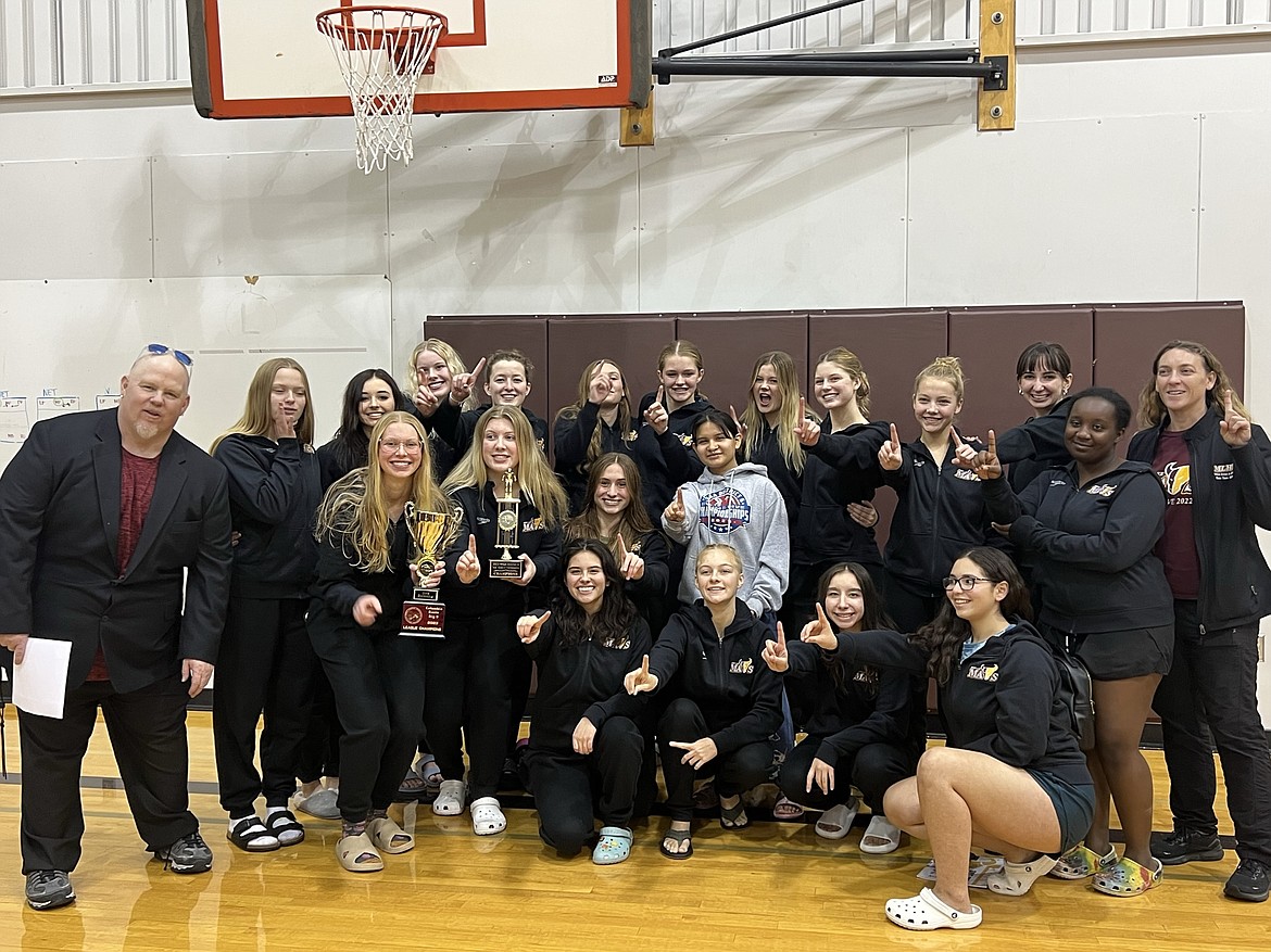 Members of the Moses Lake girls swim and dive team smile after winning a district title Saturday.