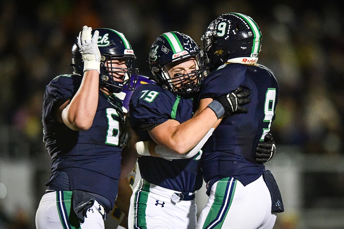 Glacier defenders Henry Sellards (66), Aiden Krause (79) and Isaac Keim (9) celebrate after Keim's sack in the first quarter against Missoula Sentinel in the quarterfinals of the Class AA playoffs at Legends Stadium on Friday, Nov. 3. (Casey Kreider/Daily Inter Lake)