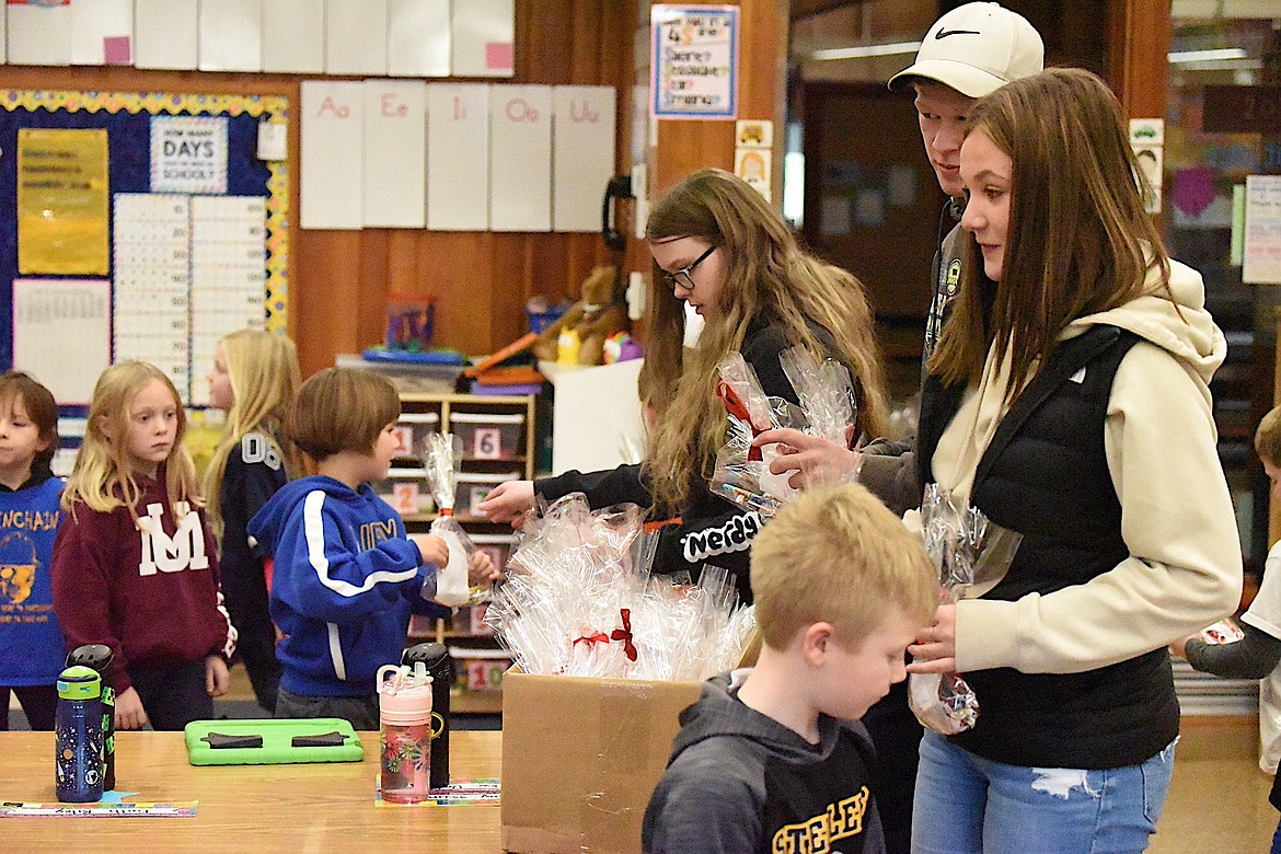 Libby High School student Ashley Cockerham, Tristan Andersen and Macie Sichting distribute goodie bags to elementary school students Friday, Nov. 3, during Red Ribbon Week. (Scott Shindledecker/The Western News)